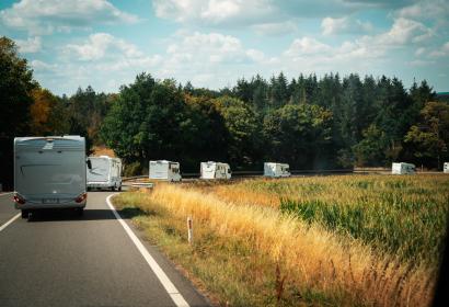 Plusieurs camping-cars qui roulent sur une route campagnarde
